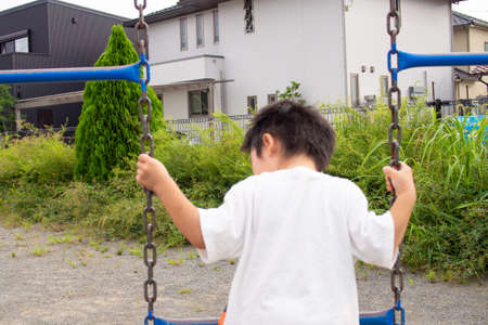 Japanese kindergarten children playing with playground equipment in a park in Gifu prefectureの写真素材