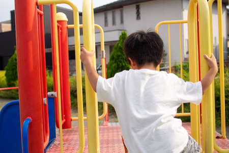 Japanese kindergarten children playing with playground equipment in a park in Gifu prefectureの写真素材