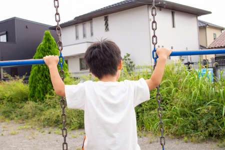 Japanese kindergarten children playing with playground equipment in a park in Gifu prefectureの写真素材