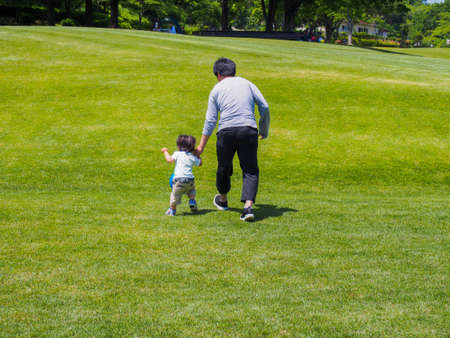 Japanese father and son playing in a nearby parkの写真素材