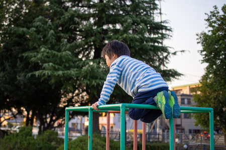 Japanese kindergarten children playing on a slide in a park in Gifu City, Gifu Prefectureの写真素材
