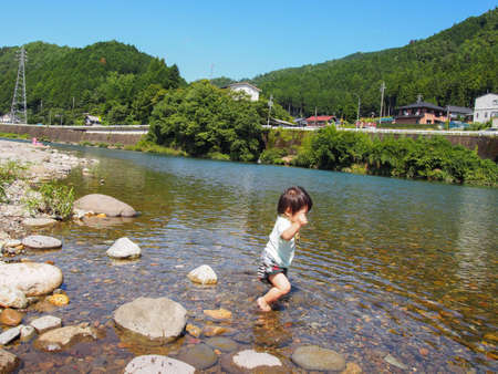 Japanese children playing in a very beautiful river in Gujo City, Gifu Prefectureの写真素材