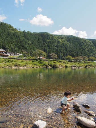 Japanese children playing in a very beautiful river in Gujo City, Gifu Prefectureの写真素材