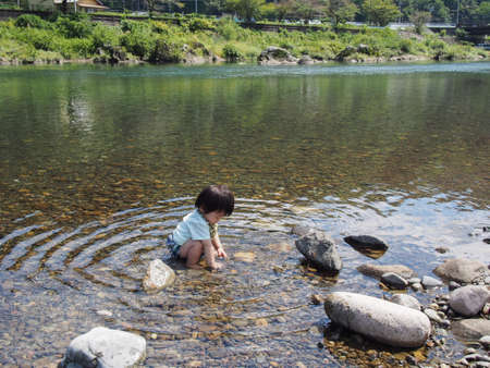 Japanese children playing in a very beautiful river in Gujo City, Gifu Prefectureの写真素材