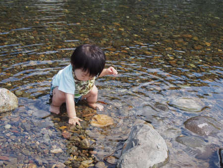 Japanese children playing in a very beautiful river in Gujo City, Gifu Prefectureの写真素材