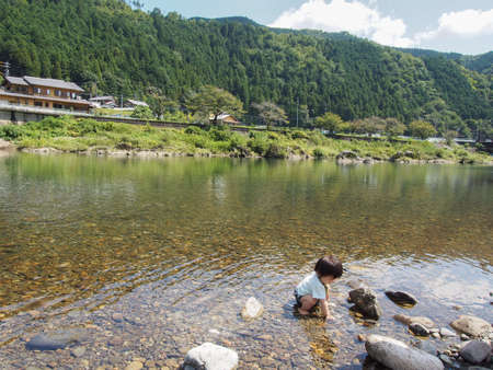 Japanese children playing in a very beautiful river in Gujo City, Gifu Prefectureの写真素材