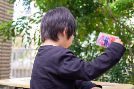 Japanese children playing in a garden with Griffith's ash treesの写真素材