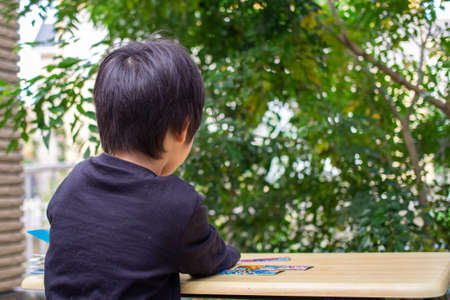 Japanese children playing in a garden with Griffith's ash treesの写真素材