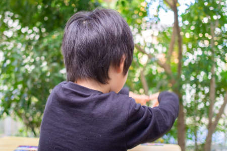 Japanese children playing in a garden with Griffith's ash treesの写真素材