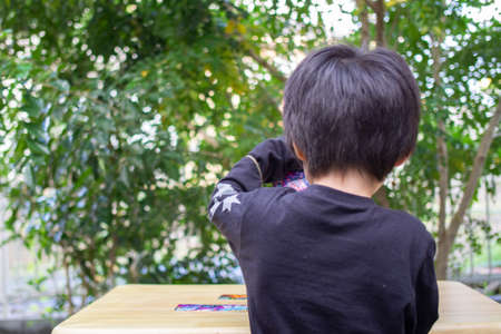 Japanese children playing in a garden with Griffith's ash treesの写真素材