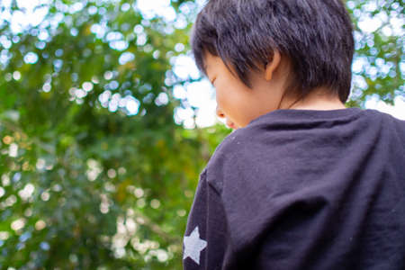 Japanese children playing in a garden with Griffith's ash treesの写真素材