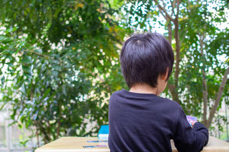 Japanese children playing in a garden with Griffith's ash treesの写真素材