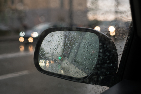 rain behind a window. rain drops on glass. cars on the road. heavy rainの写真素材