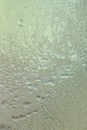 Water drops on a window, textured background, pastel colors, defocused shotの写真素材