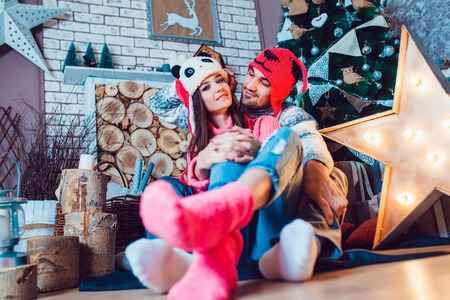 A  beautiful loving couple in funny hats posing in Christmas decorationsの写真素材