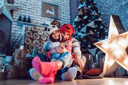 A  beautiful loving couple in funny hats posing in Christmas decorationsの写真素材