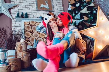 A  beautiful loving couple in funny hats posing in Christmas decorationsの写真素材