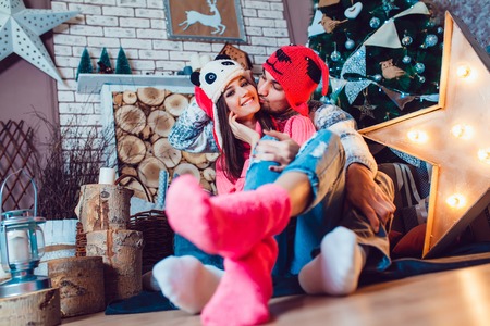 A  beautiful loving couple in funny hats posing in Christmas decorationsの写真素材