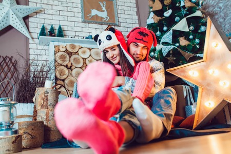 A  beautiful loving couple in funny hats posing in Christmas decorationsの写真素材