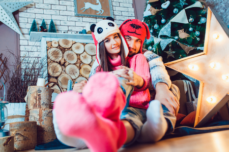 A  beautiful loving couple in funny hats posing in Christmas decorationsの写真素材