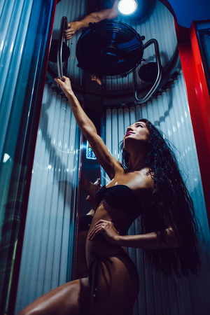 Beautiful girl posing in a bathing suit in the solariumの写真素材
