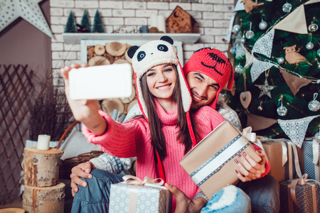Beautiful couple in love in Christmas decorations make the selfieの写真素材