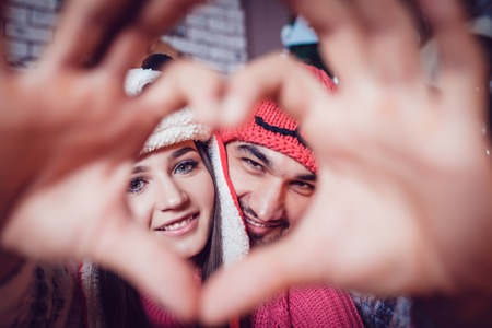 Beautiful Loving couple hands show sign of loveの写真素材