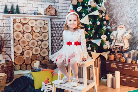 Girl dressed as Santa Claus posing with Christmas decorationsの写真素材