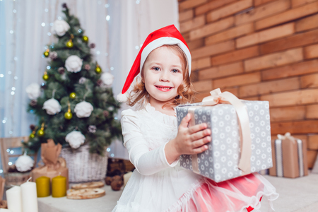 Girl dressed as Santa Claus posing with Christmas decorationsの写真素材