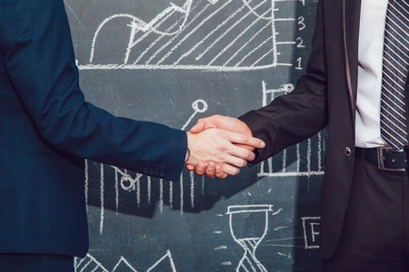 Handshake on background with charts. Jacket. Tieの写真素材