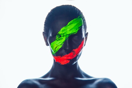 Girl with a black paint on the face. Green and red stripes.Isolate.の写真素材