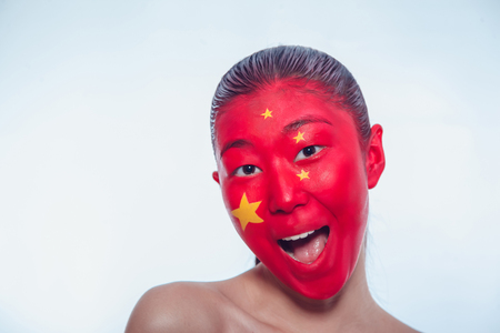 Girl with a Chinese flag on the faceの写真素材