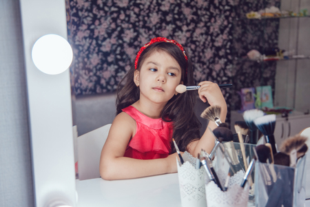 Little girl in hair curlers in a beauty studioの写真素材