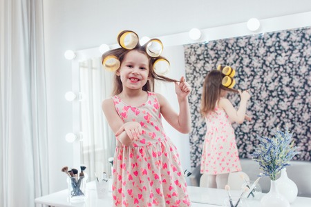 Little girl in hair curlers in a beauty studioの写真素材