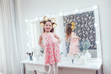 Little girl in hair curlers in a beauty studioの写真素材