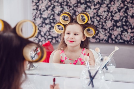Little girl in hair curlers in a beauty studioの写真素材