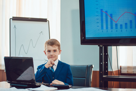 Children businessmen are meeting in the office sitting at the computerの写真素材
