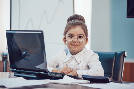 Children businessmen are meeting in the office sitting at the computerの写真素材