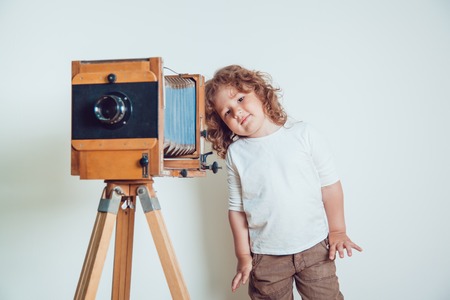 Little boy standing near the camera on a white background