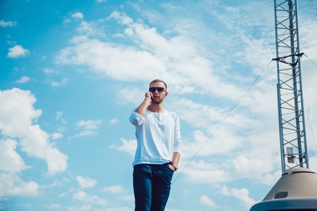 Man talking on the phone on the roof. Mobile antenna. Sky.の写真素材