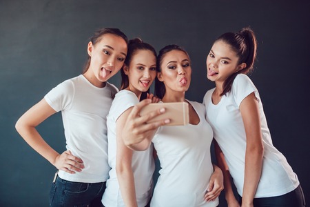 Positive friends portrait of happy girls making selfie