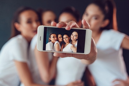 Positive friends portrait of happy girls making selfieの写真素材