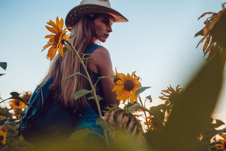 Girl in a cowboy hat in a sunflower field. Sunsetの写真素材