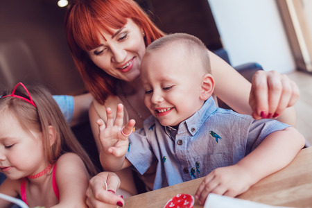 Woman sitting in a restaurant with son in her armsの写真素材
