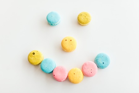 French macaroons laid out in the shape of smiley on a white backgroundの写真素材