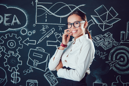 Portrait of a business woman with glasses on a background with business figuresの写真素材