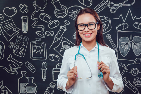 Portrait of young woman doctor with white coat standing in hospitalの写真素材