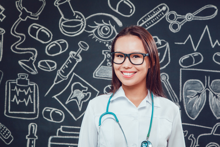 Portrait of young woman doctor with white coat standing in hospitalの写真素材