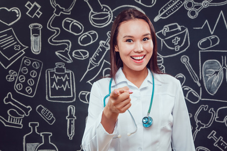 Portrait of young woman doctor with white coat standing in hospitalの写真素材