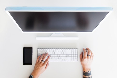 Man hand on desktop keyboard with blank screen monitorの写真素材